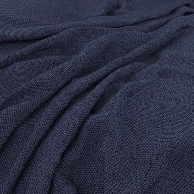 Deep marine navy fabric with a finely pebbled woven texture in gathered folds
