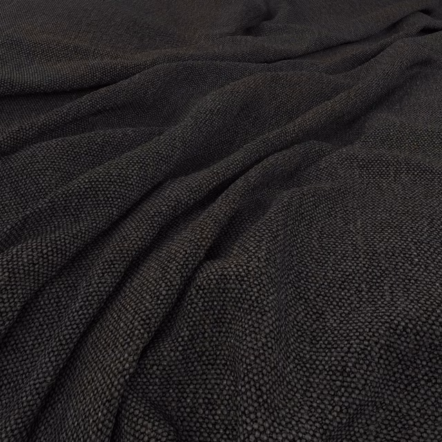 Deep charcoal-black woven textile with pebbled texture arranged in soft flowing folds