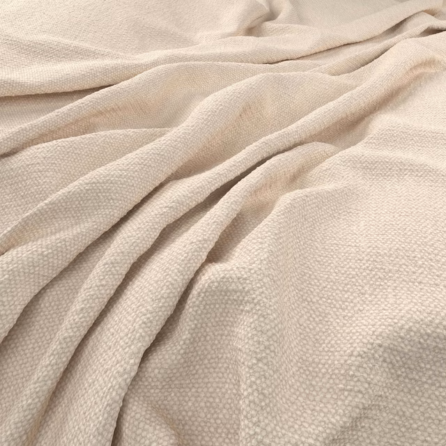 Warm vanilla woven fabric with pebbled texture gathered into soft folds