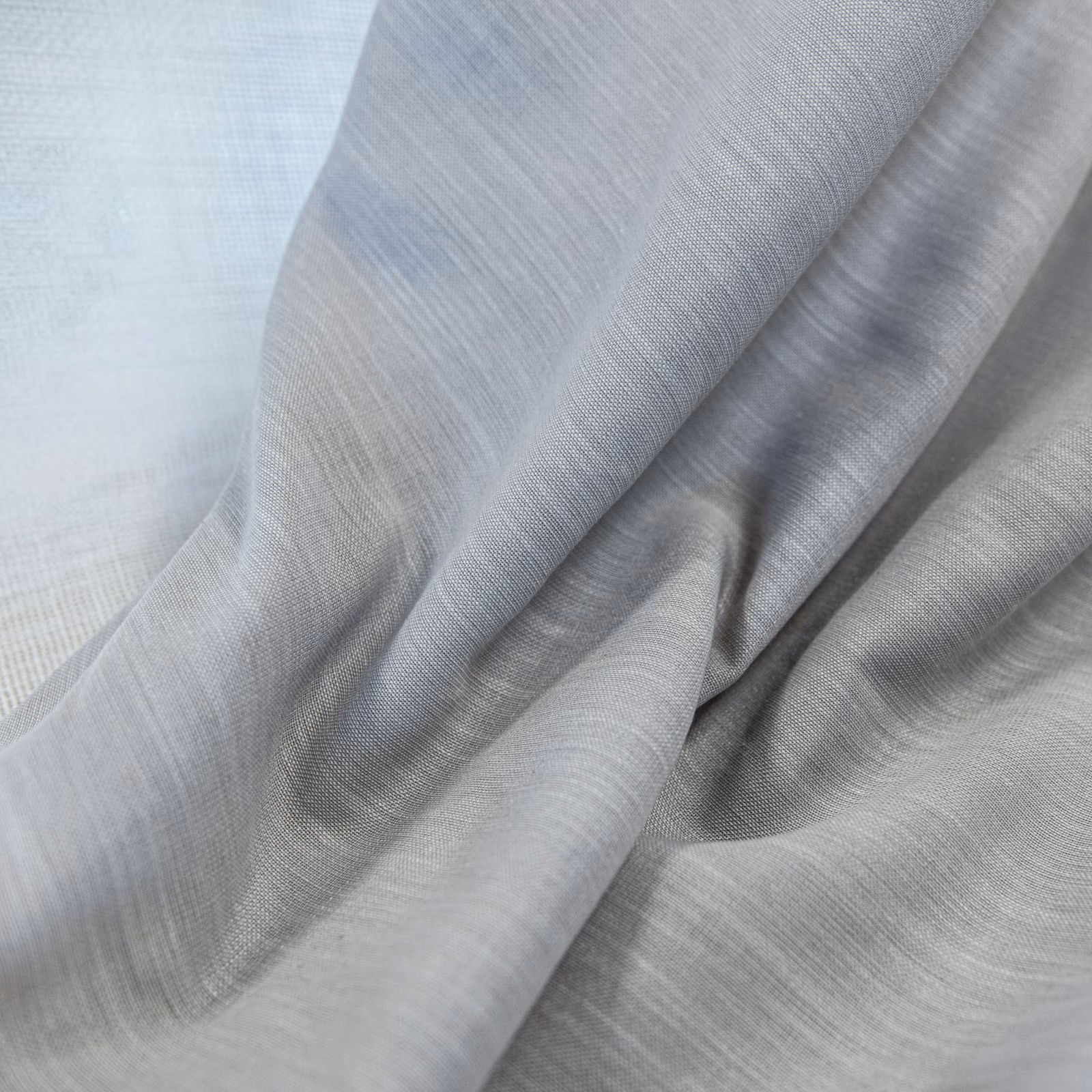 Cool ash-grey woven fabric draped in soft folds with subtle silver highlights