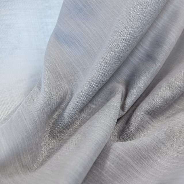 Cool ash-grey woven fabric draped in soft folds with subtle silver highlights