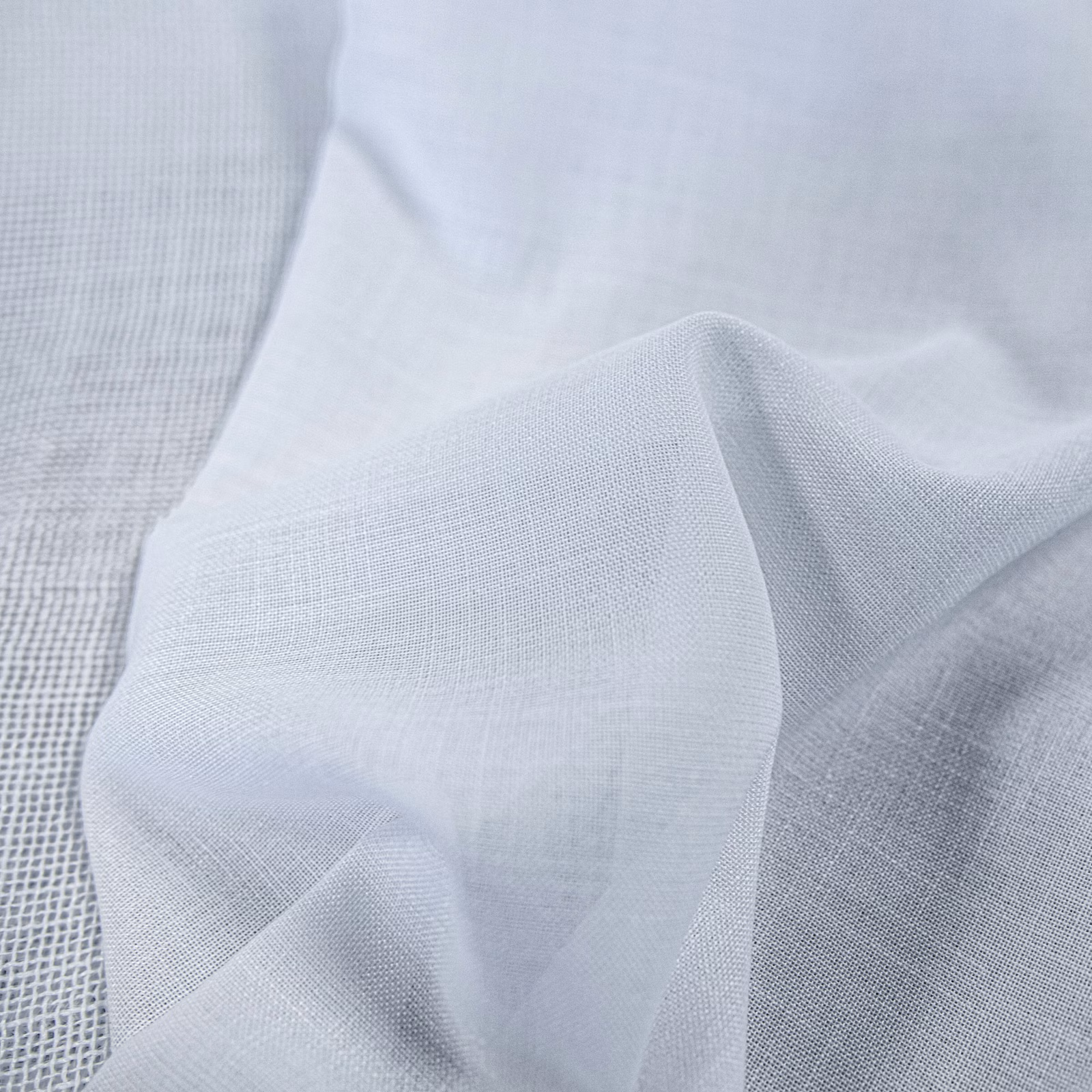 Pale blue-grey fine plain weave fabric folded to show a soft translucent texture