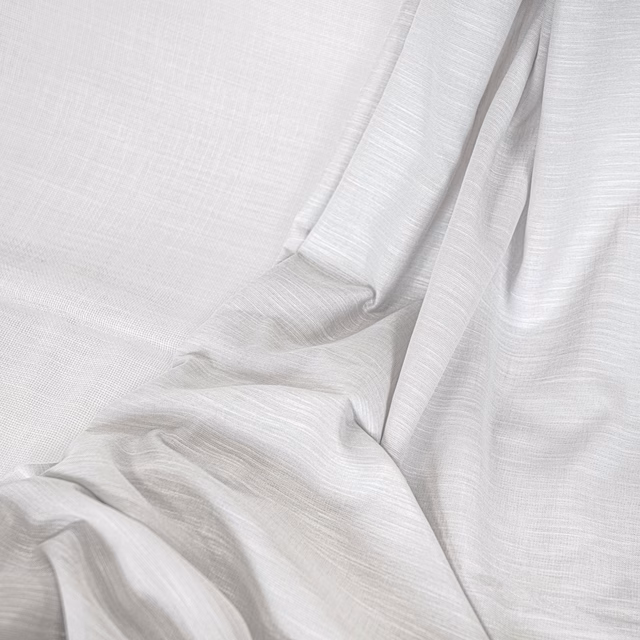 Soft optic-white textile with fine horizontal weave falling in fluid rippled folds