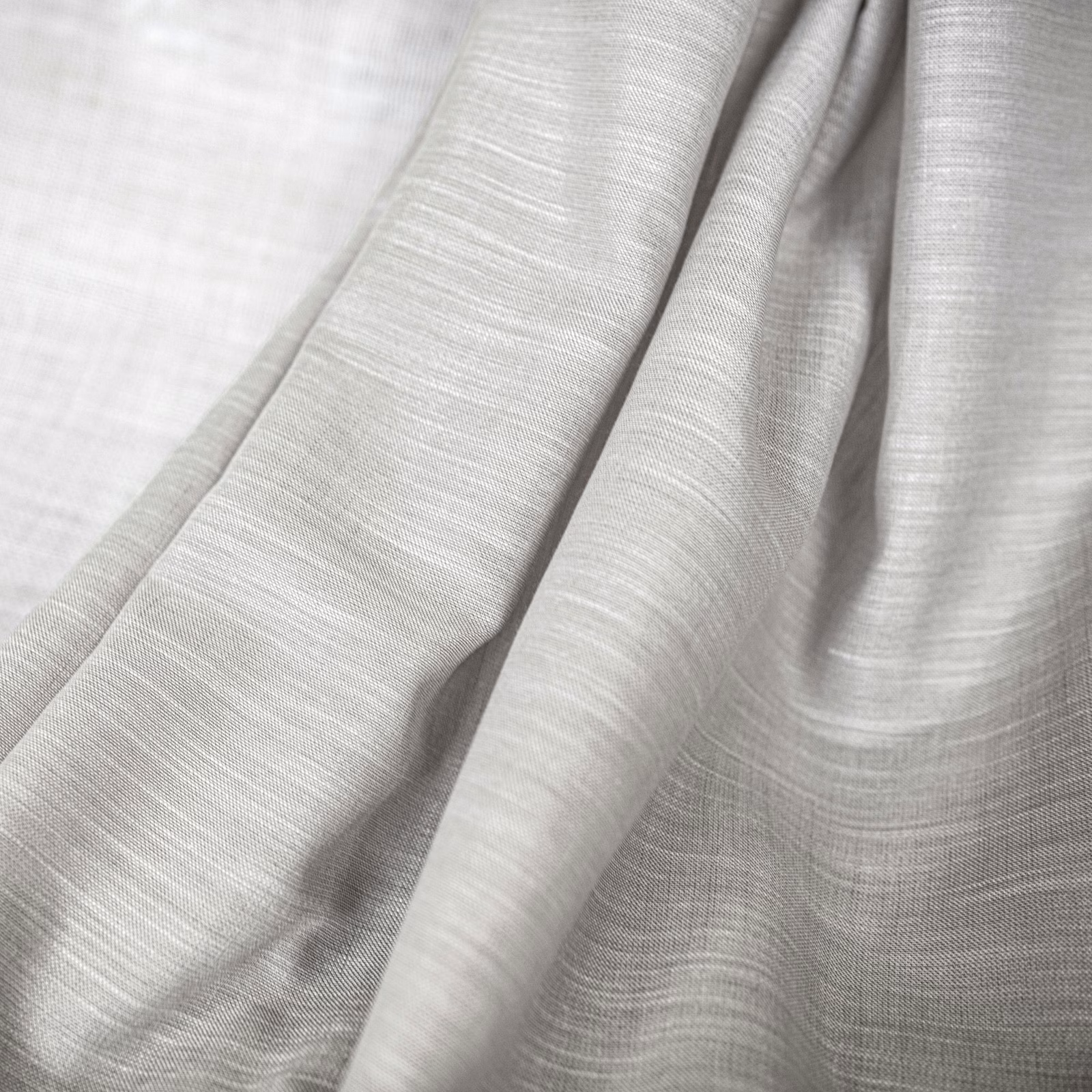 Pale oyster-grey fabric with fine horizontal weave falling in soft fluid folds