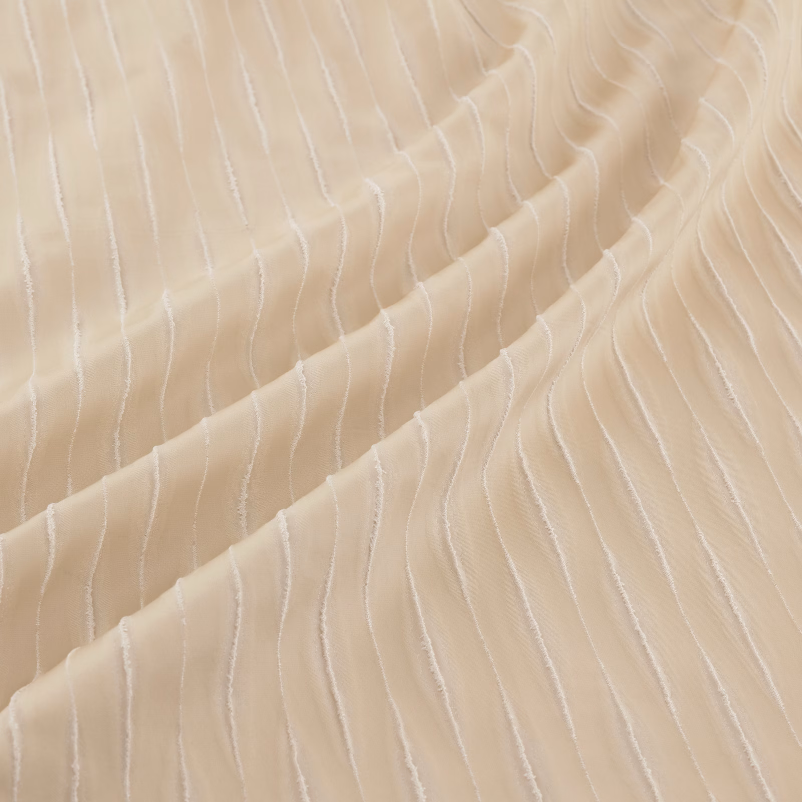 Warm champagne-gold fabric with irregular ivory lines folding into a fluid drape
