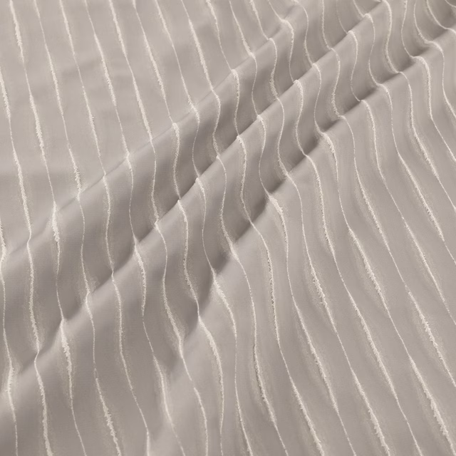 Iron-grey fabric with raised, irregular pale waves and soft gathered folds