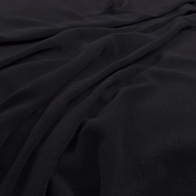 Near-black charcoal cloth in soft folds with a subtle fine woven texture