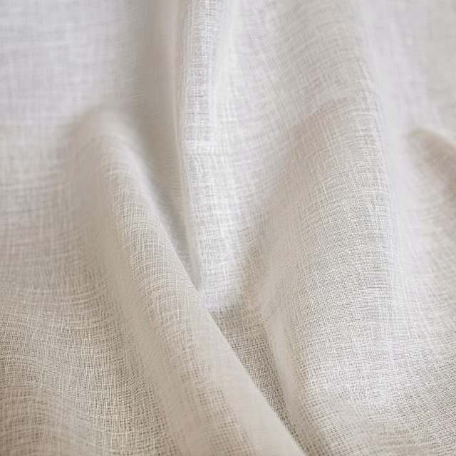 Pale ivory cream fabric with a fine open crosshatched weave folded into soft drapery pleats