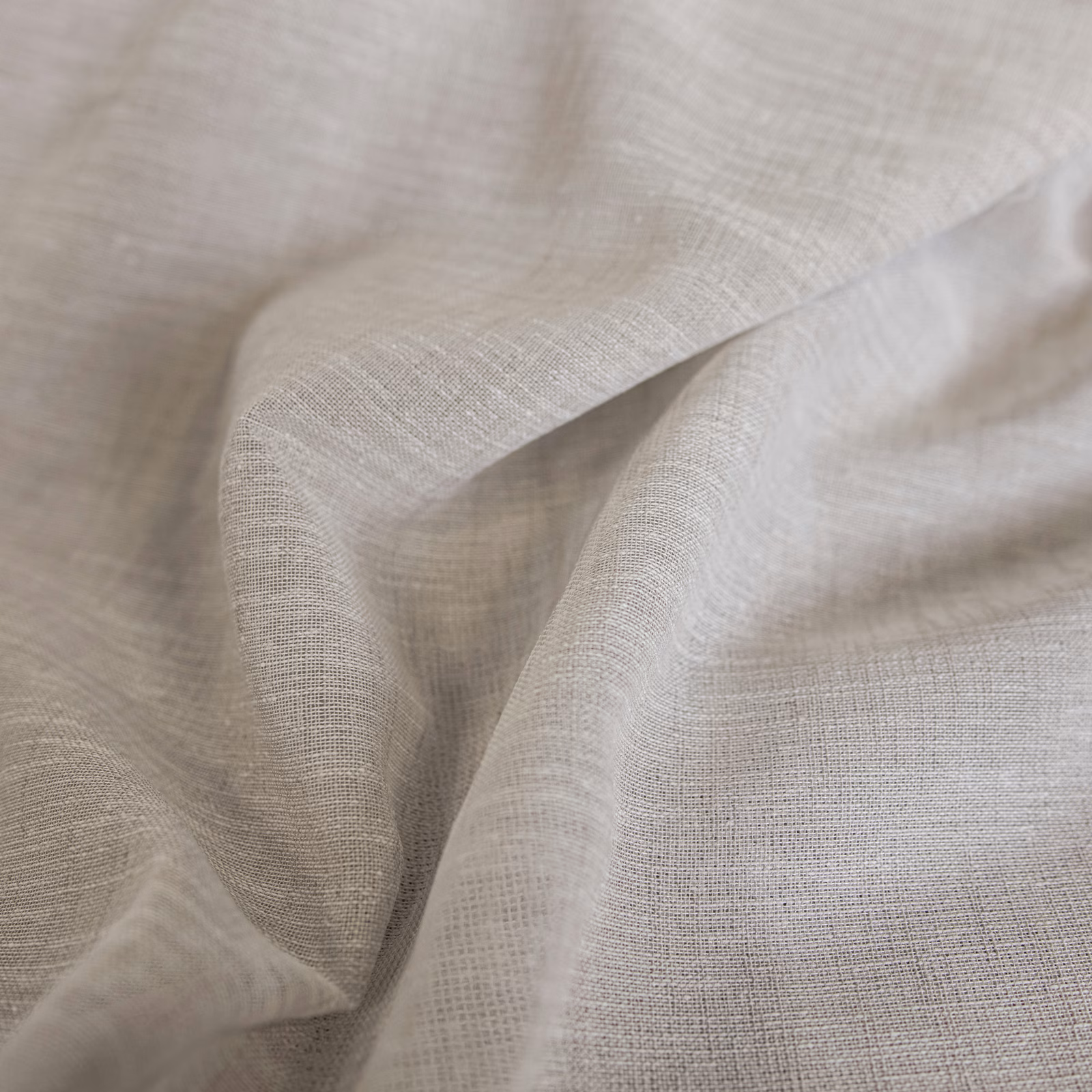 Soft natural greige woven cloth in close-up, showing fine open texture and folds.