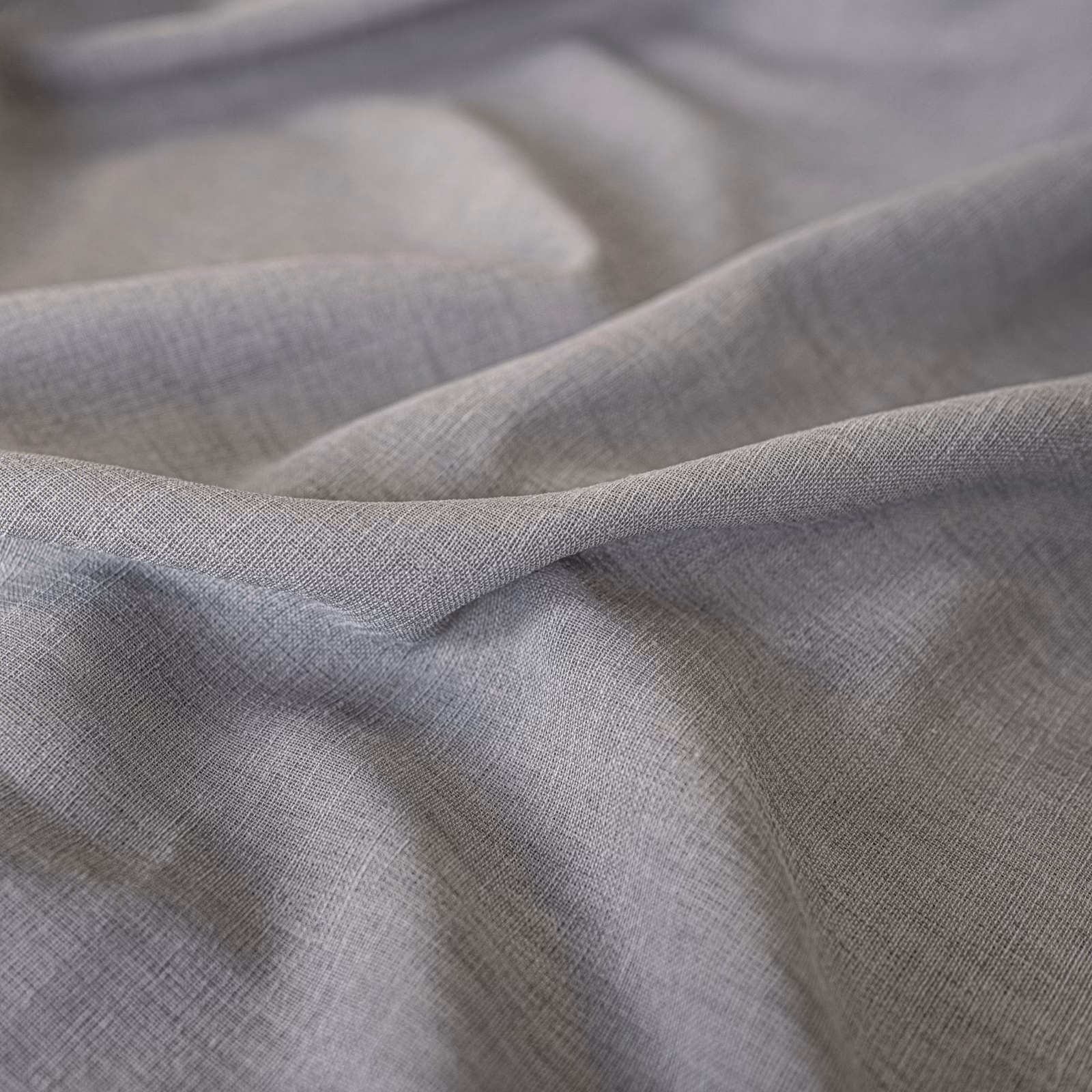 Cool pebble-grey fine weave gathered into softly shadowed fabric folds