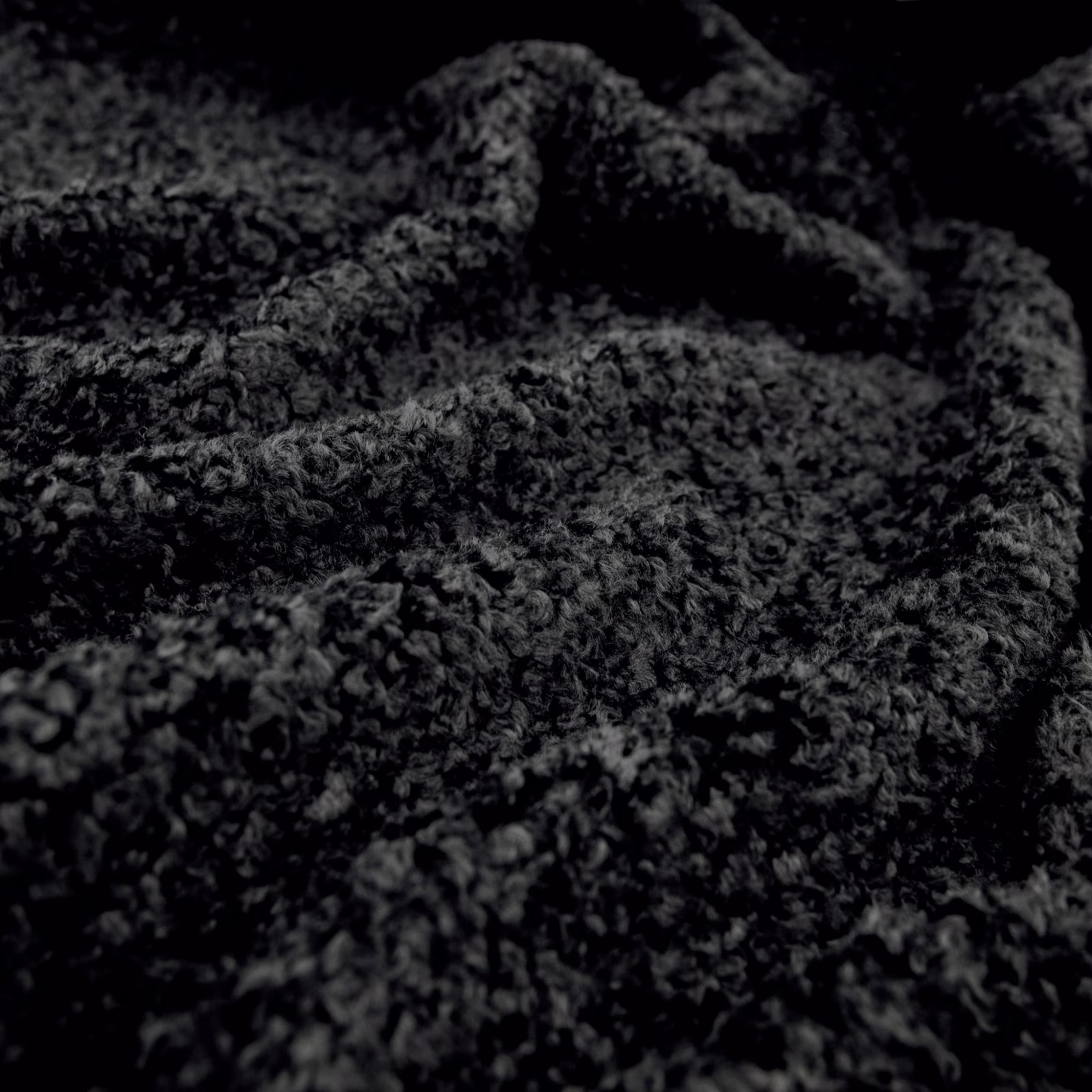 Near-black Lambert textile with charcoal looped pile and deep folded texture