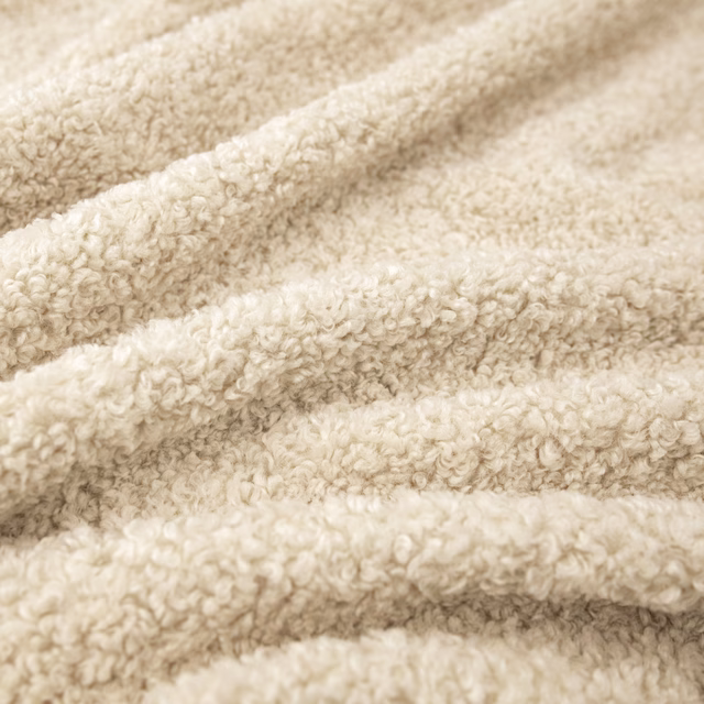 Close view of warm ivory looped pile forming soft raised folds