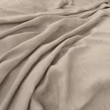 Pale ecru fine-weave cloth shown in softly gathered, fluid folds
