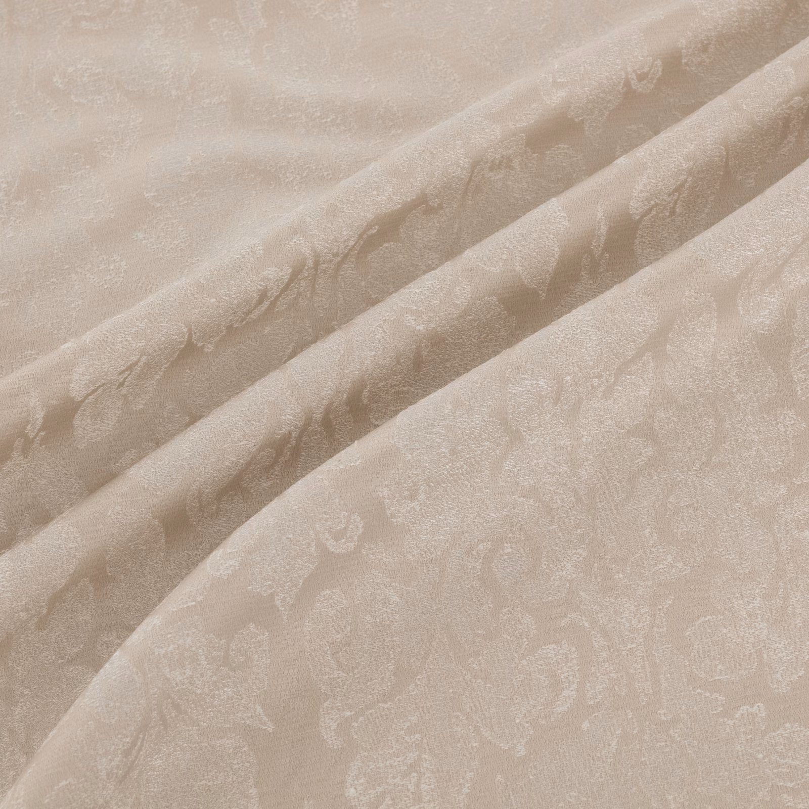 Warm ivory-beige fabric in soft folds with tonal paisley and scrolling motifs