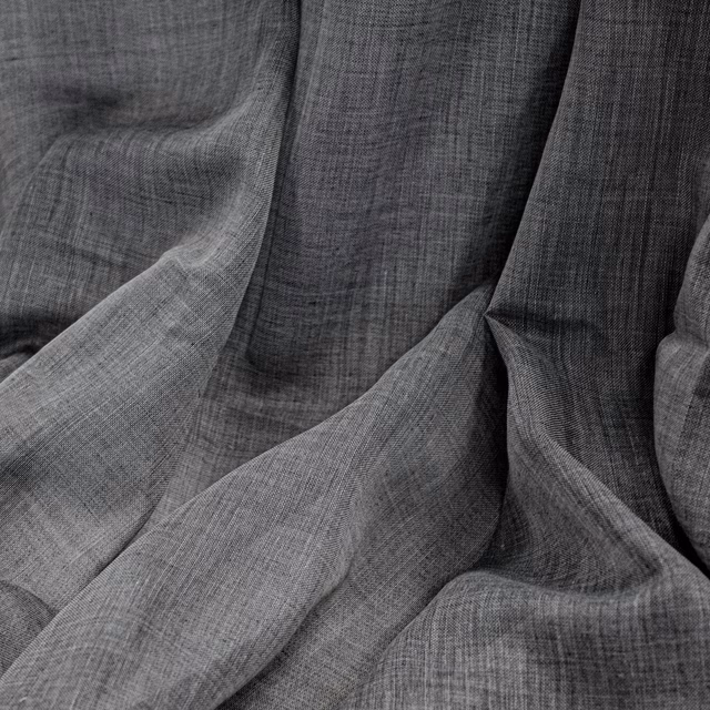 Cool charcoal grey woven fabric with fine crosshatch texture in fluid folds