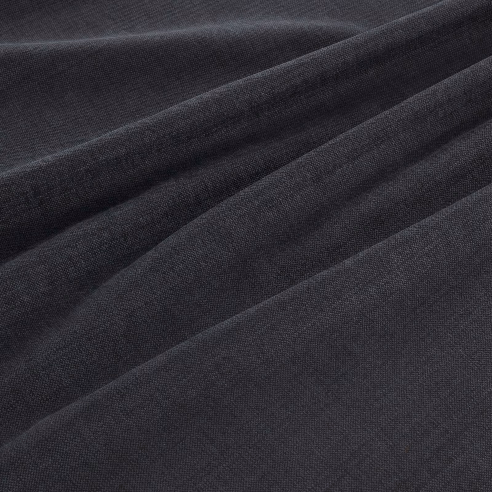 Anthracite grey fine weave fabric draped in softly folded, near-black ridges