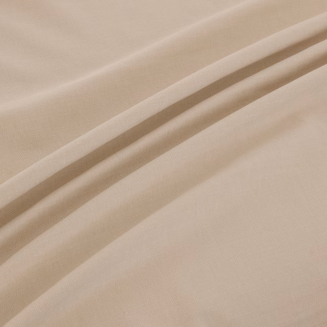 Warm champagne-beige plain weave fabric gathered into soft diagonal folds