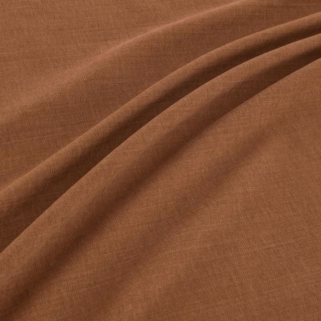 Warm cognac-brown plain weave fabric shown in soft folds with subtle tonal shading
