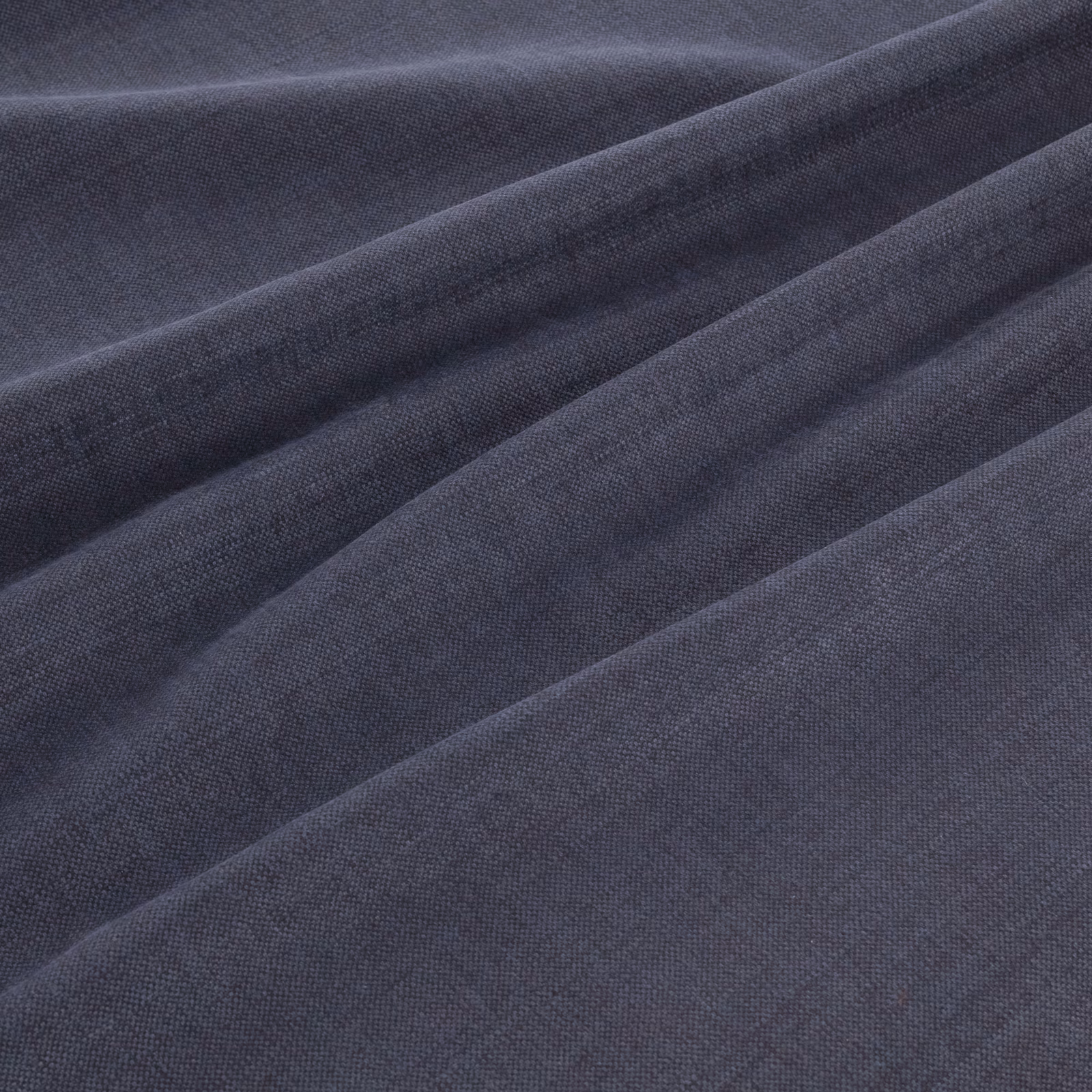 Deep denim-blue woven fabric folded into soft ridges, showing a fine even texture