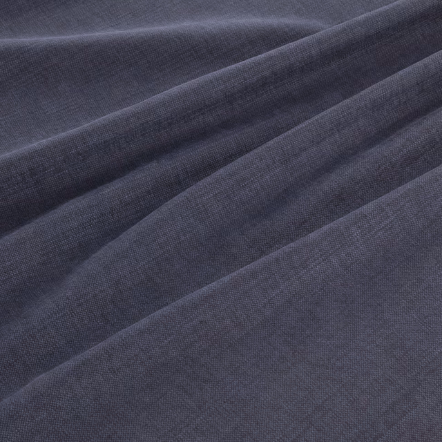 Deep denim-blue woven fabric folded into soft ridges, showing a fine even texture