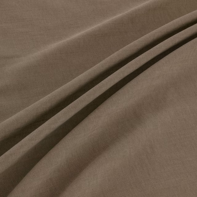 Close-up of warm taupe woven fabric folded into soft, shadowed ridges