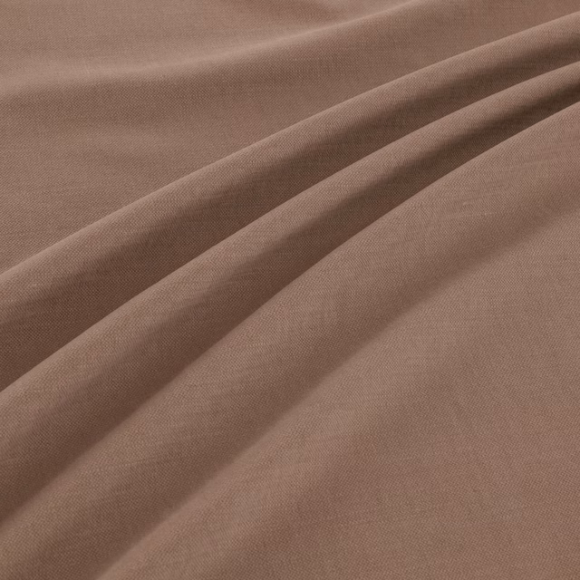Muted mushroom taupe plain weave fabric shown in soft diagonal folds
