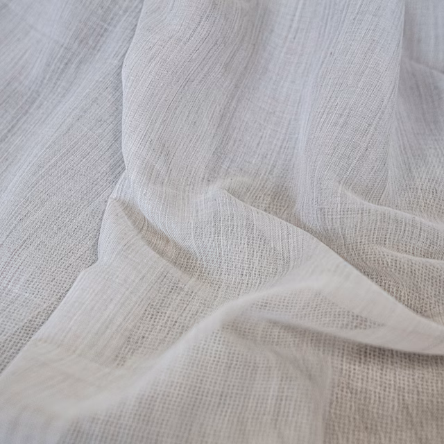Warm ecru open gauze weave draped in soft, translucent folds