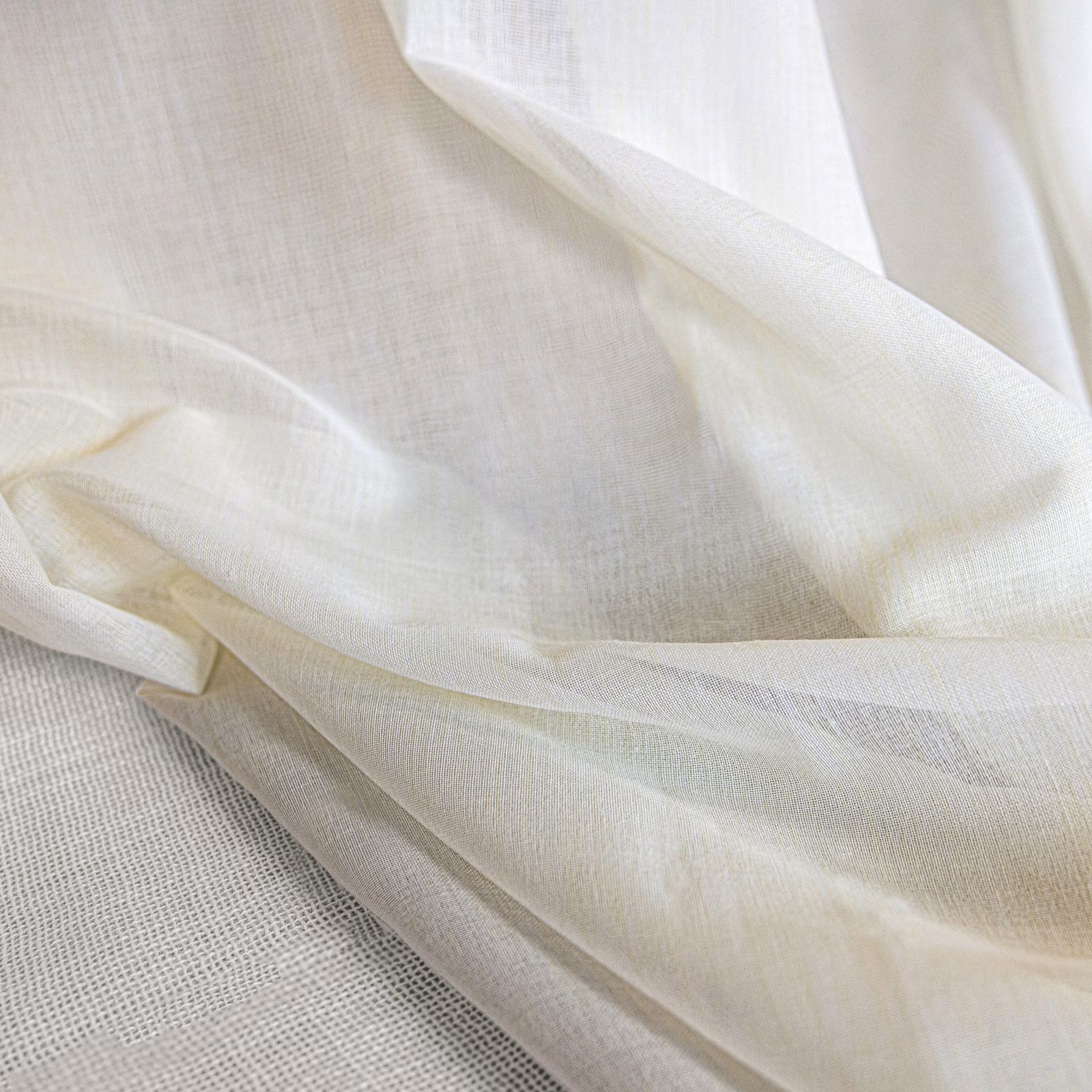 Warm ivory translucent cloth with fine crossweave and softly folded sheer texture