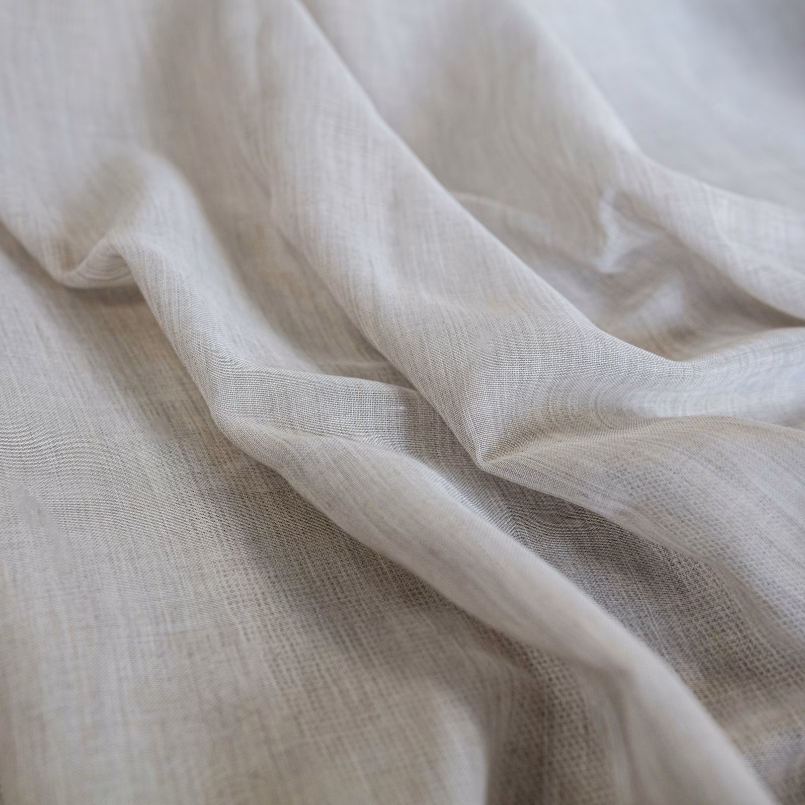 Warm ivory-beige open weave fabric draped in soft, translucent folds