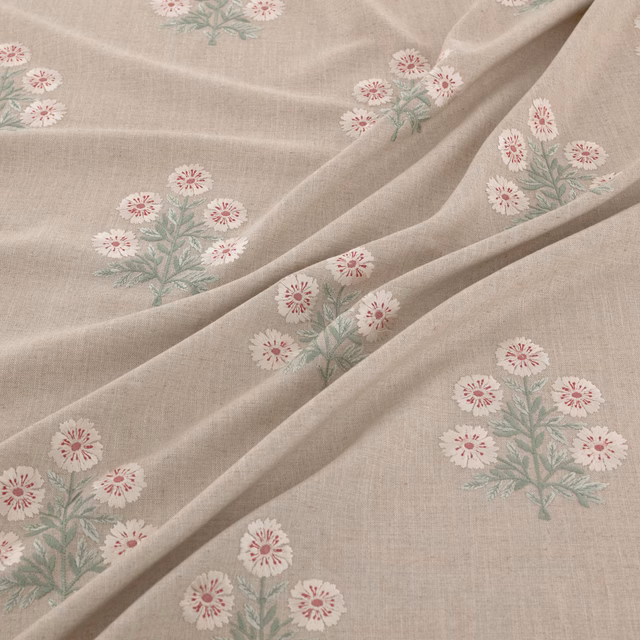 Pale taupe woven ground with blush daisy clusters and sage foliage in soft folds