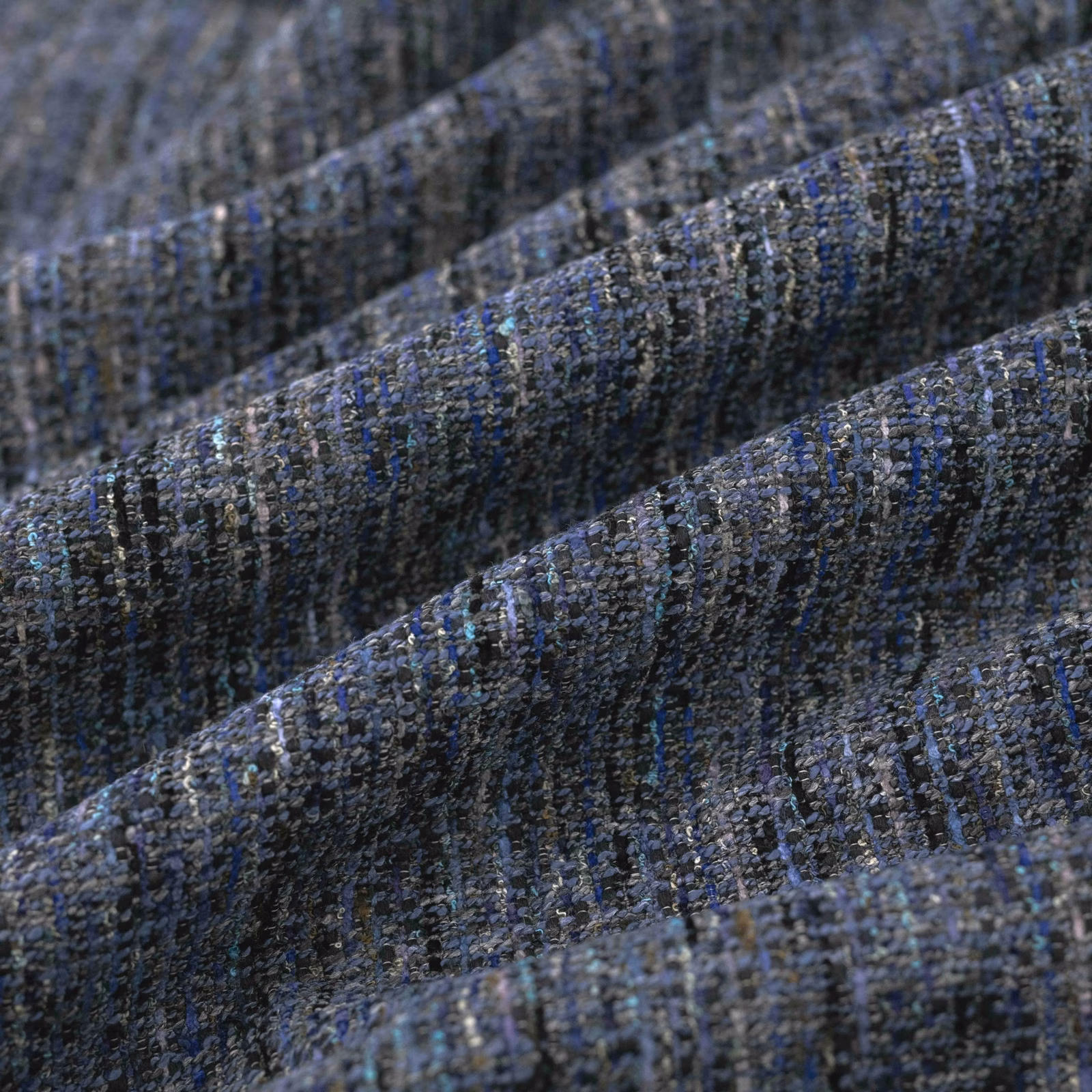 Close-up of deep slate-blue woven fabric with charcoal flecks and ridged texture