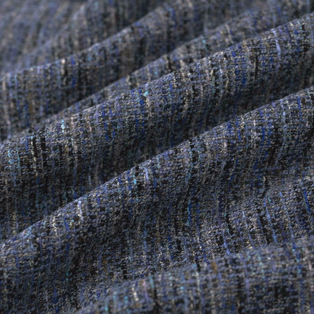 Close-up of deep slate-blue woven fabric with charcoal flecks and ridged texture
