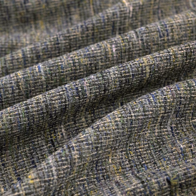 Close-up of olive-grey crosshatched fabric with blue and yellow flecks