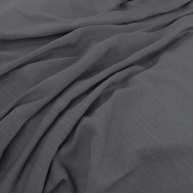 Deep charcoal-grey plain fabric falling into soft, fluid folds