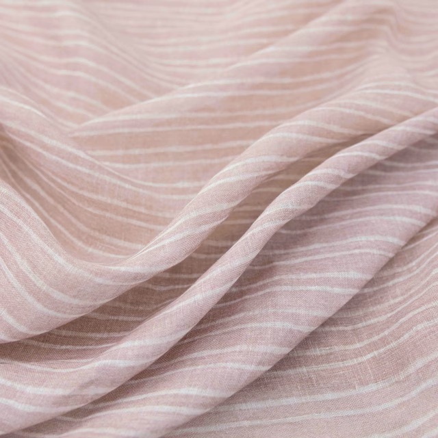 Dusty blush fabric with ivory wavy stripes and softly folded woven texture