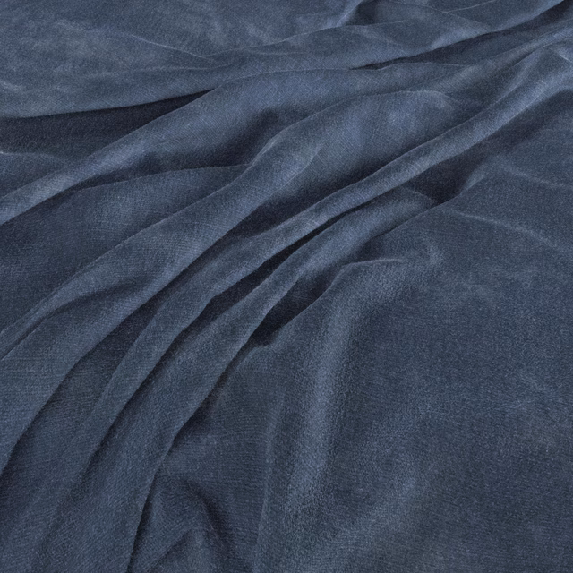 Deep ink-blue woven fabric gathered into soft folds with subtle slate highlights