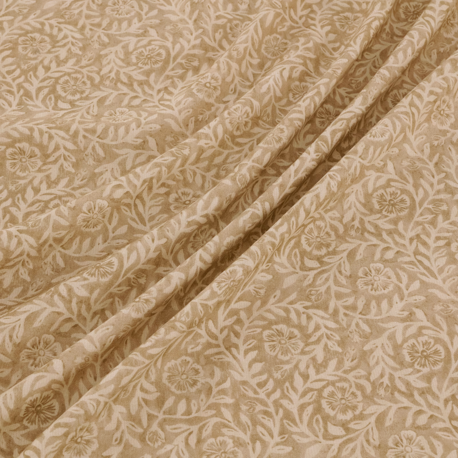 Warm dune-beige fabric with ivory scrolling flowers, leaves and softly textured woven surface
