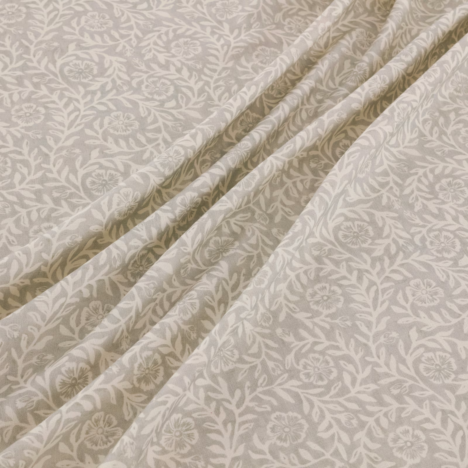 Warm gull-grey fabric with ivory trailing florals gathered into soft folds