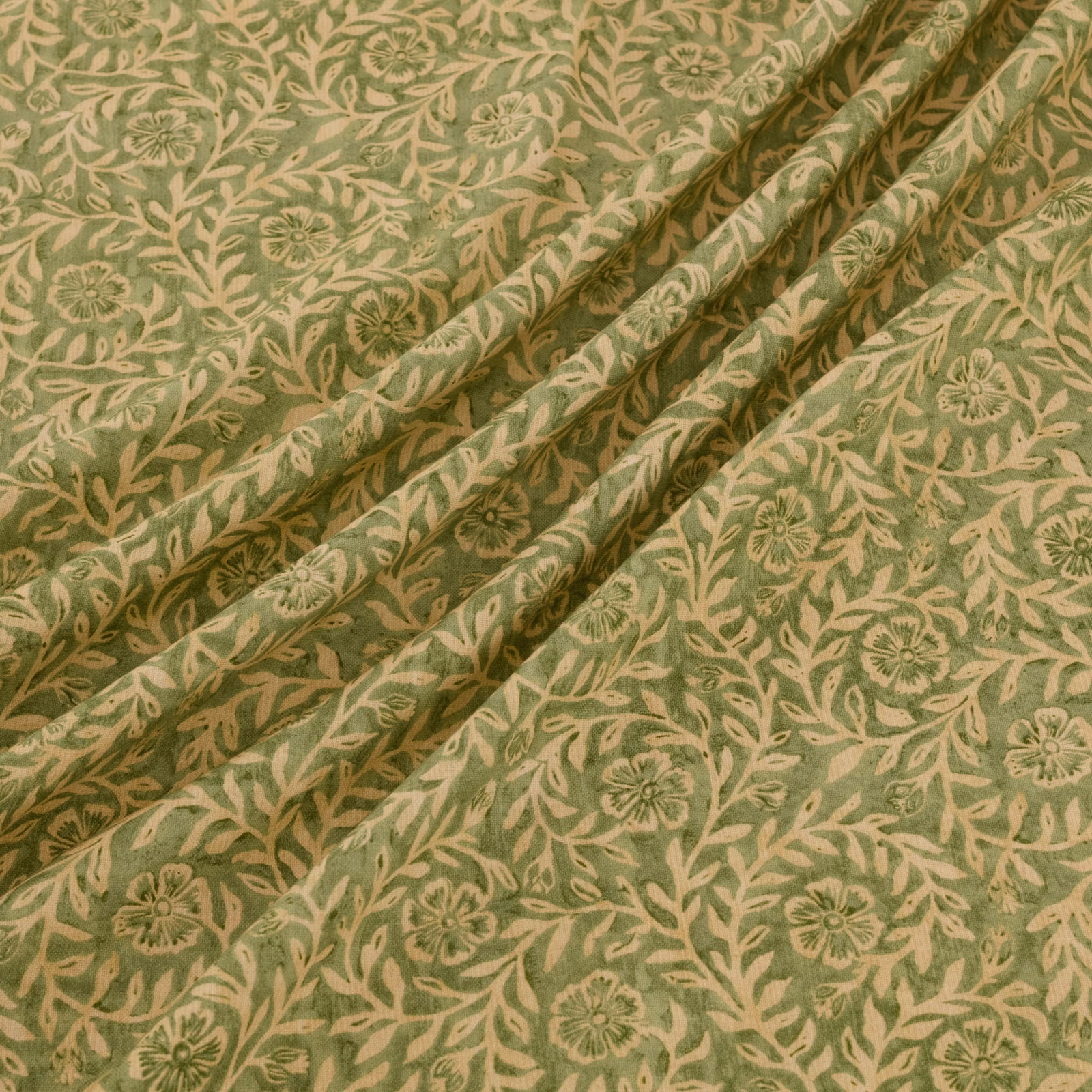 Muted olive-green fabric with beige trailing foliage and small floral motifs in gathered folds