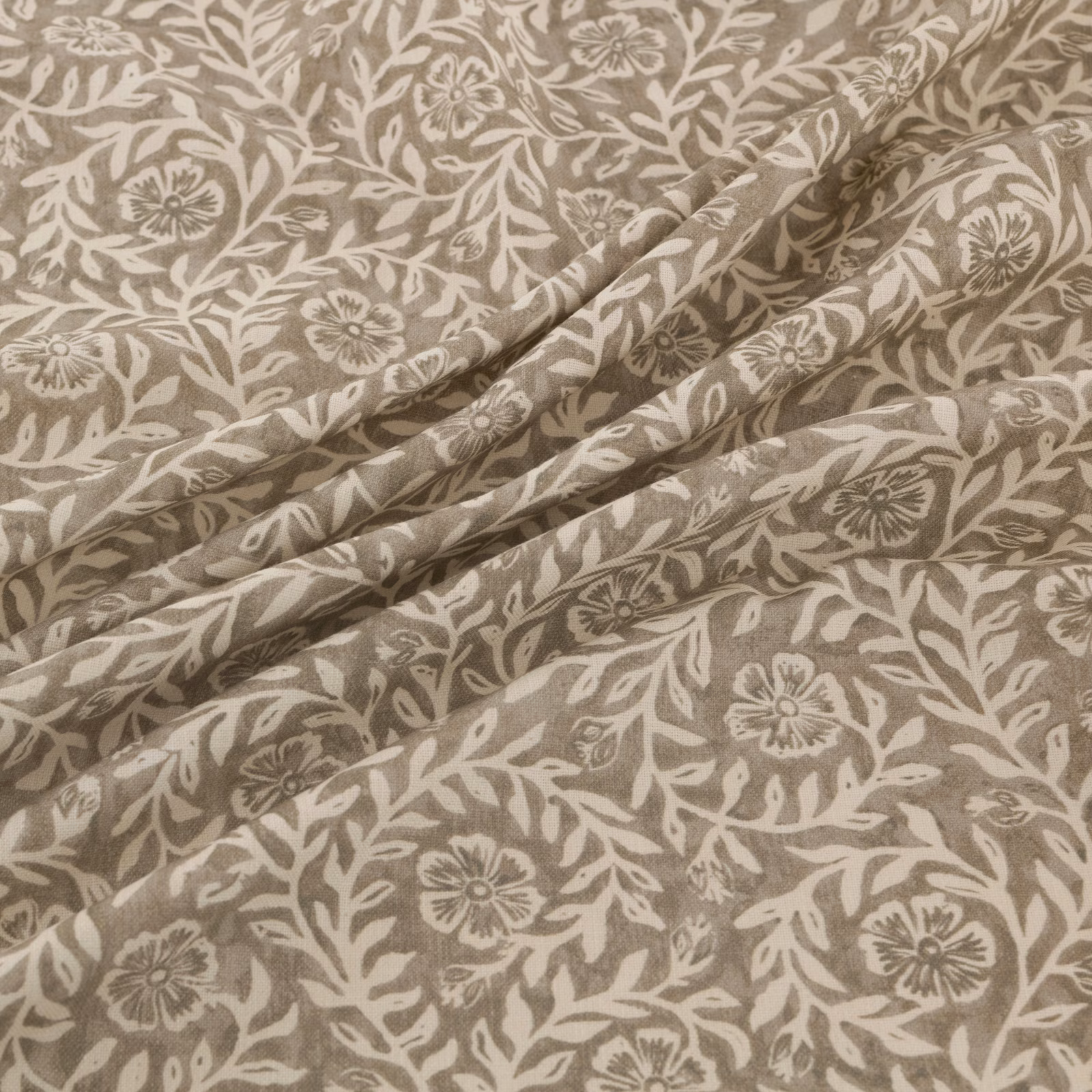 Taupe floral fabric with cream botanical trails and softly folded texture