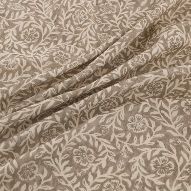 Taupe floral fabric with cream botanical trails and softly folded texture