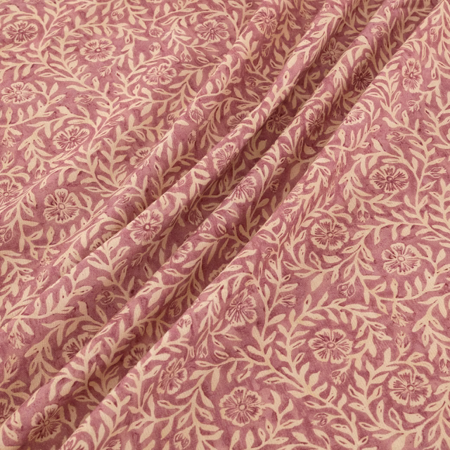 Dusty rose floral fabric with cream vines and folded botanical drape