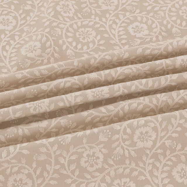 Warm taupe-beige woven fabric with cream floral sprays and scrolling stems in folded view