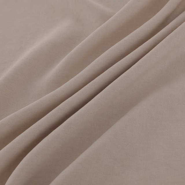 Warm flax-beige plain weave with fine texture folding into soft diagonal drapes