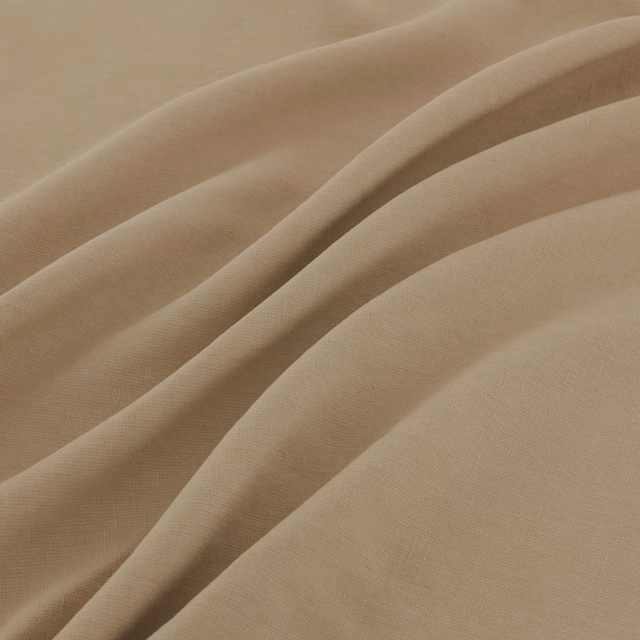 Warm papyrus beige woven fabric falling into broad, softly shadowed folds