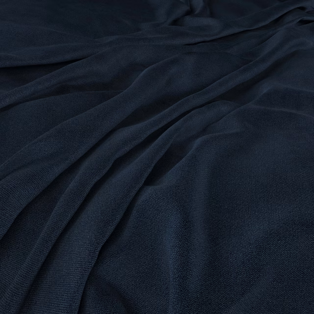 Deep ink-navy woven fabric draped into soft folds with a subtle sheen
