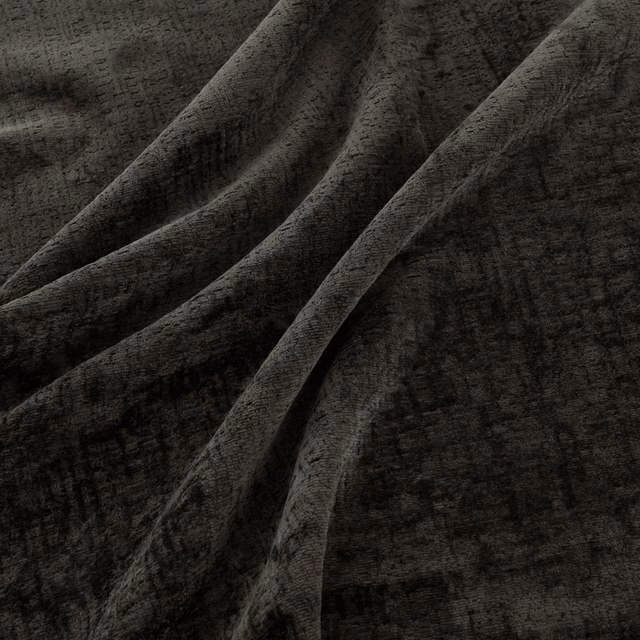 Dark charcoal fabric with distressed gridded texture folding into deep shadowed pleats
