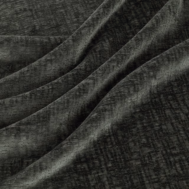 Deep graphite-grey textured fabric with mottled crosshatching folded into soft diagonal ridges