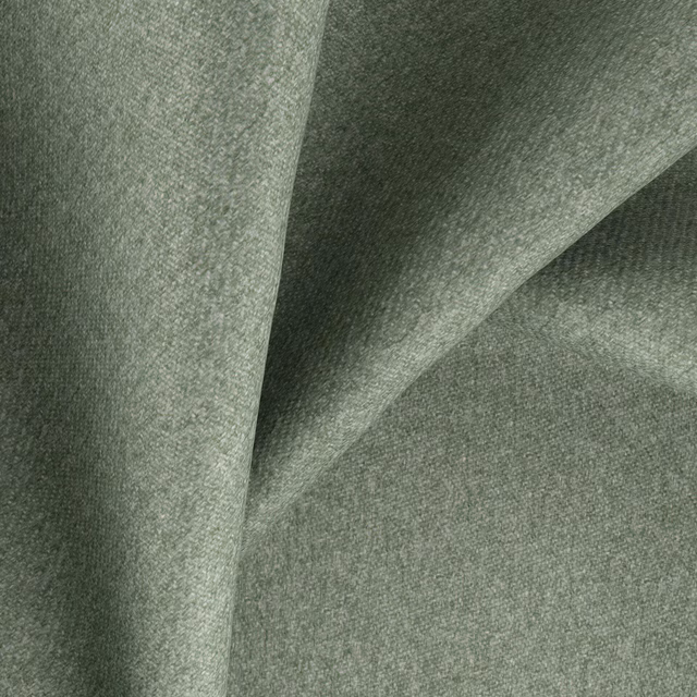 Muted sage-green woven textile with a softly mottled surface falling into broad folds