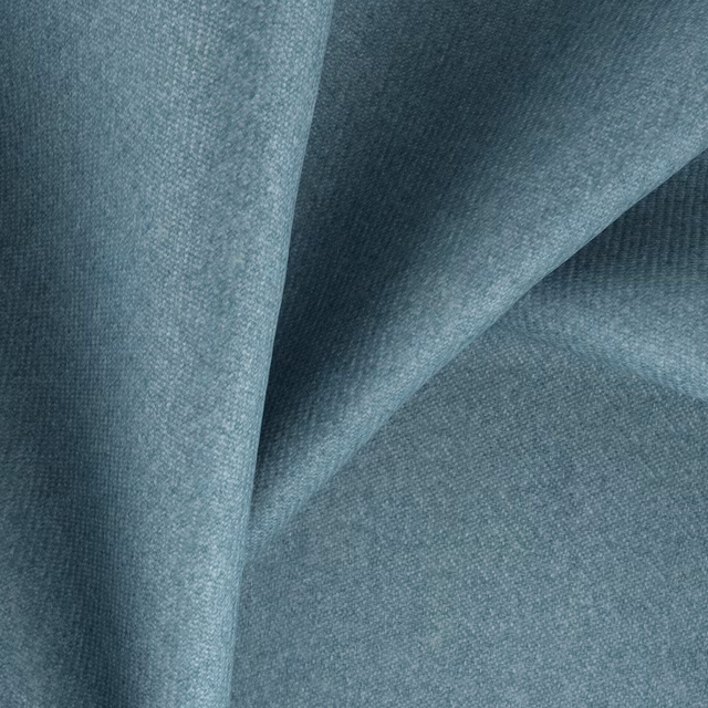 Muted blue-teal woven fabric folded to show fine grain and shaded texture